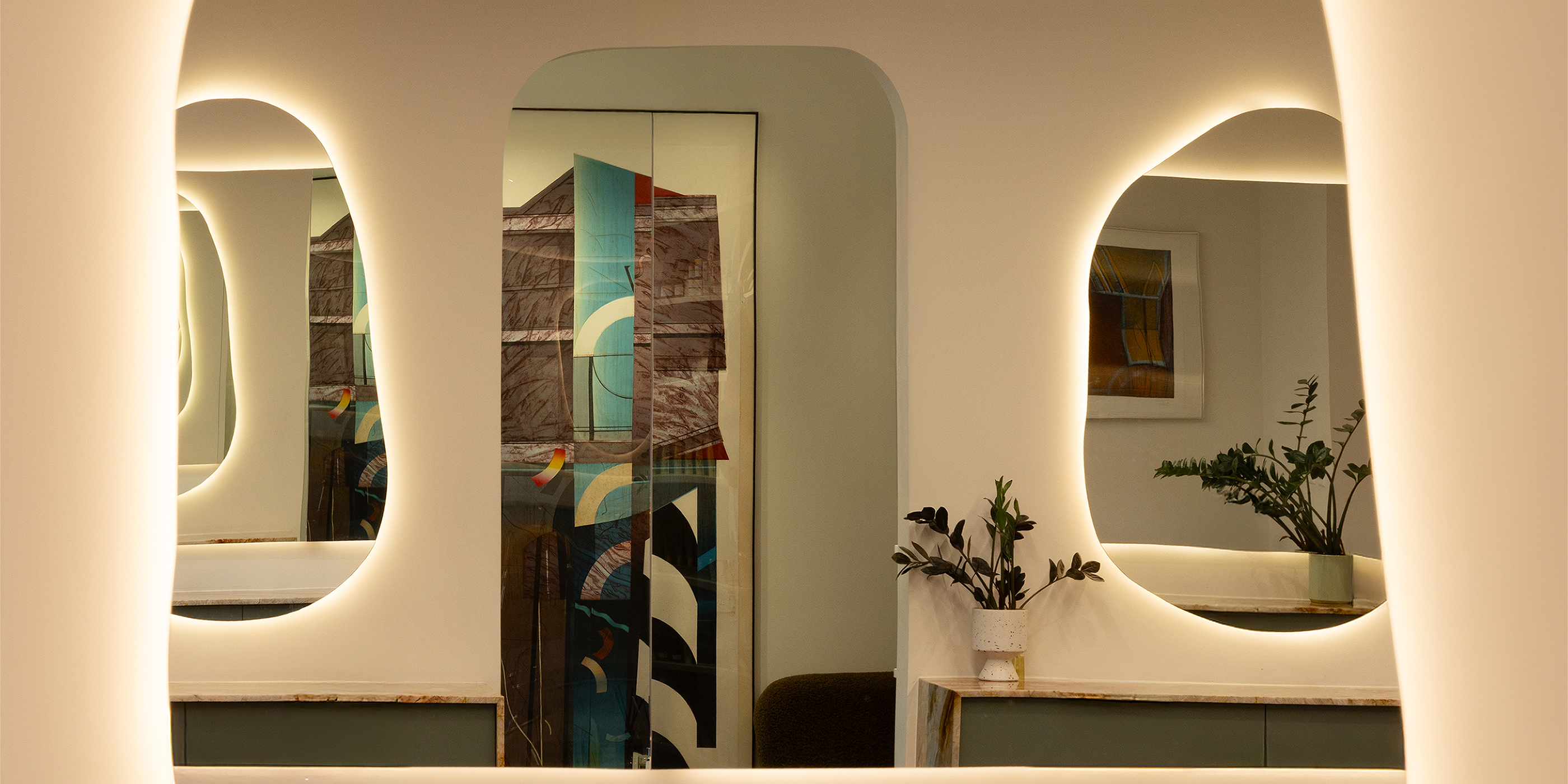 Modern vanity with a large oval mirror featuring embedded lighting.