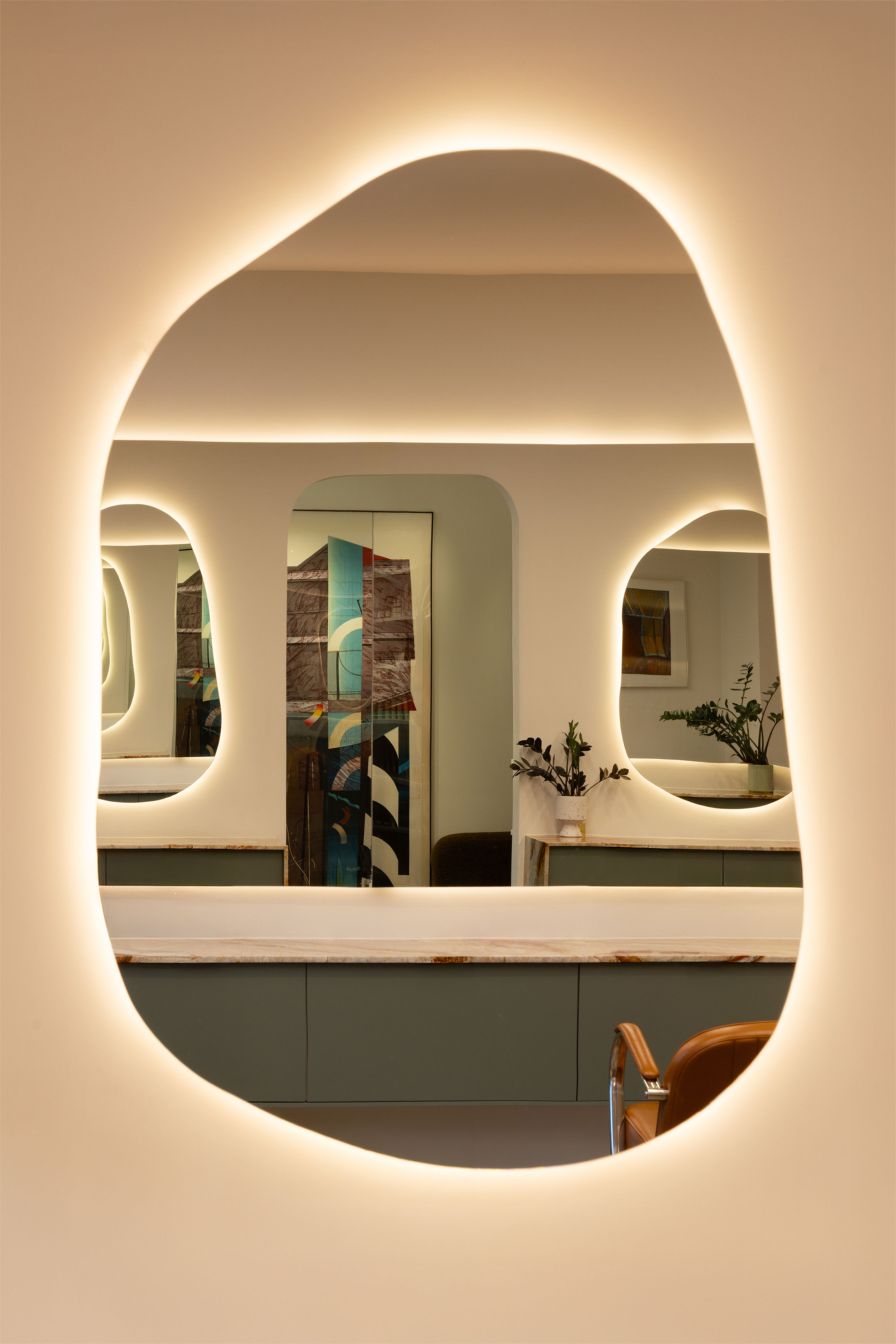 Modern vanity with a large oval mirror featuring embedded lighting.