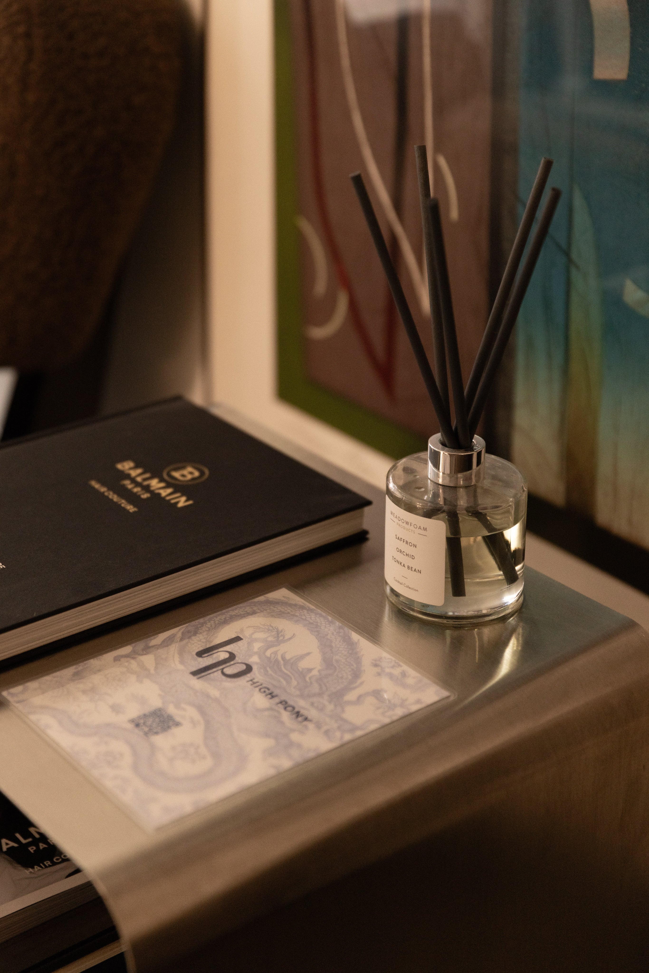 A diffuser bottle on a surface with a blurred background
