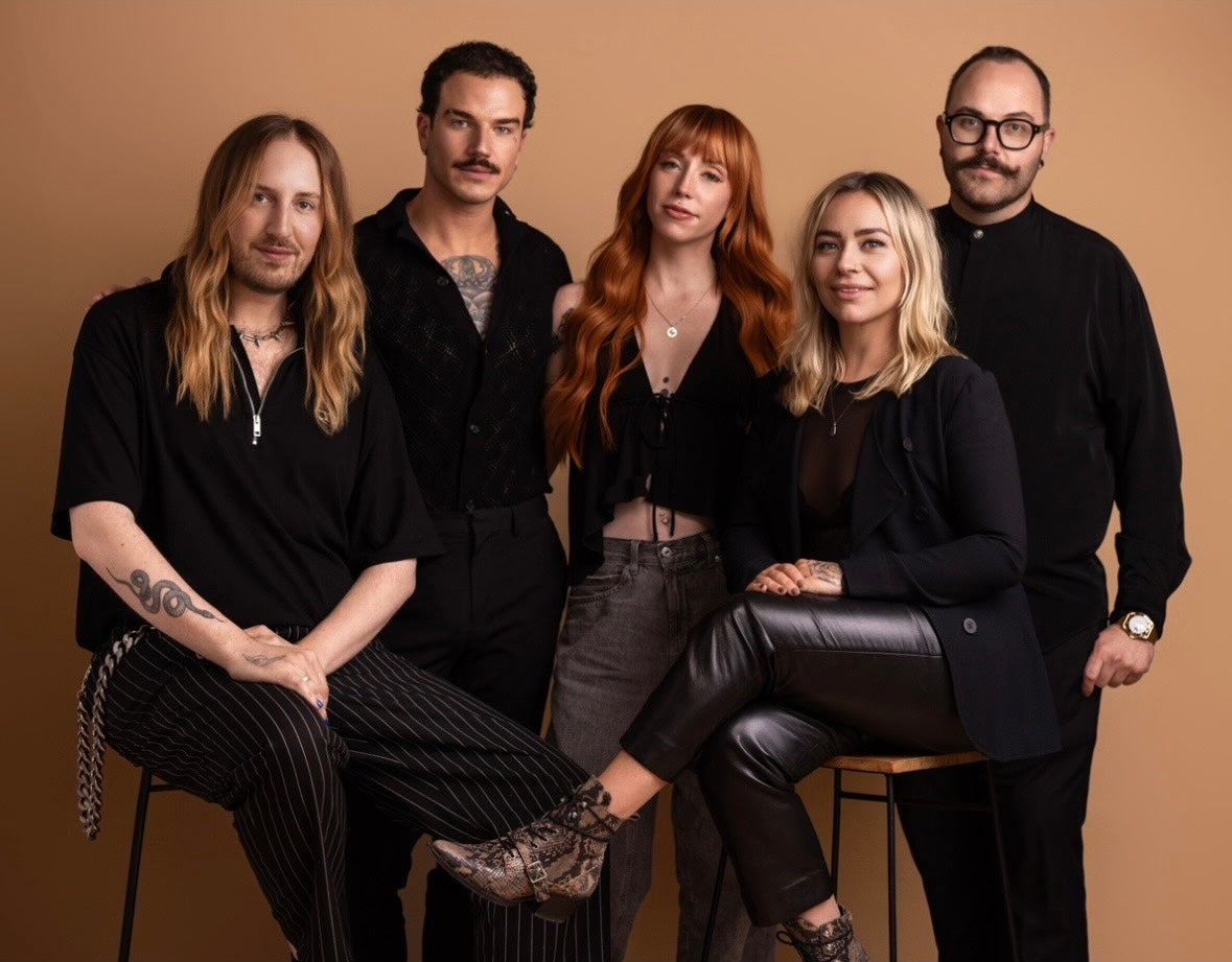 Five HIGH PONY SALON employees posing together against a brown background