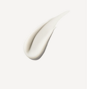 Close-up of a white cream or paint swatch on a light gray background