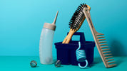 Set of grooming tools including a bottle, brush, and comb on a blue background