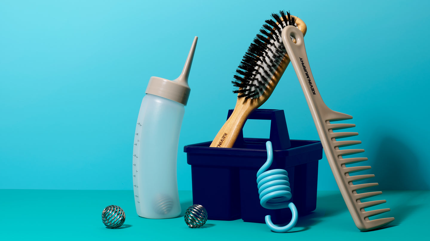 Set of grooming tools including a bottle, brush, and comb on a blue background