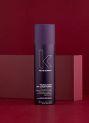 Kevin Murphy Young Again Dry Conditioner bottle on a red background