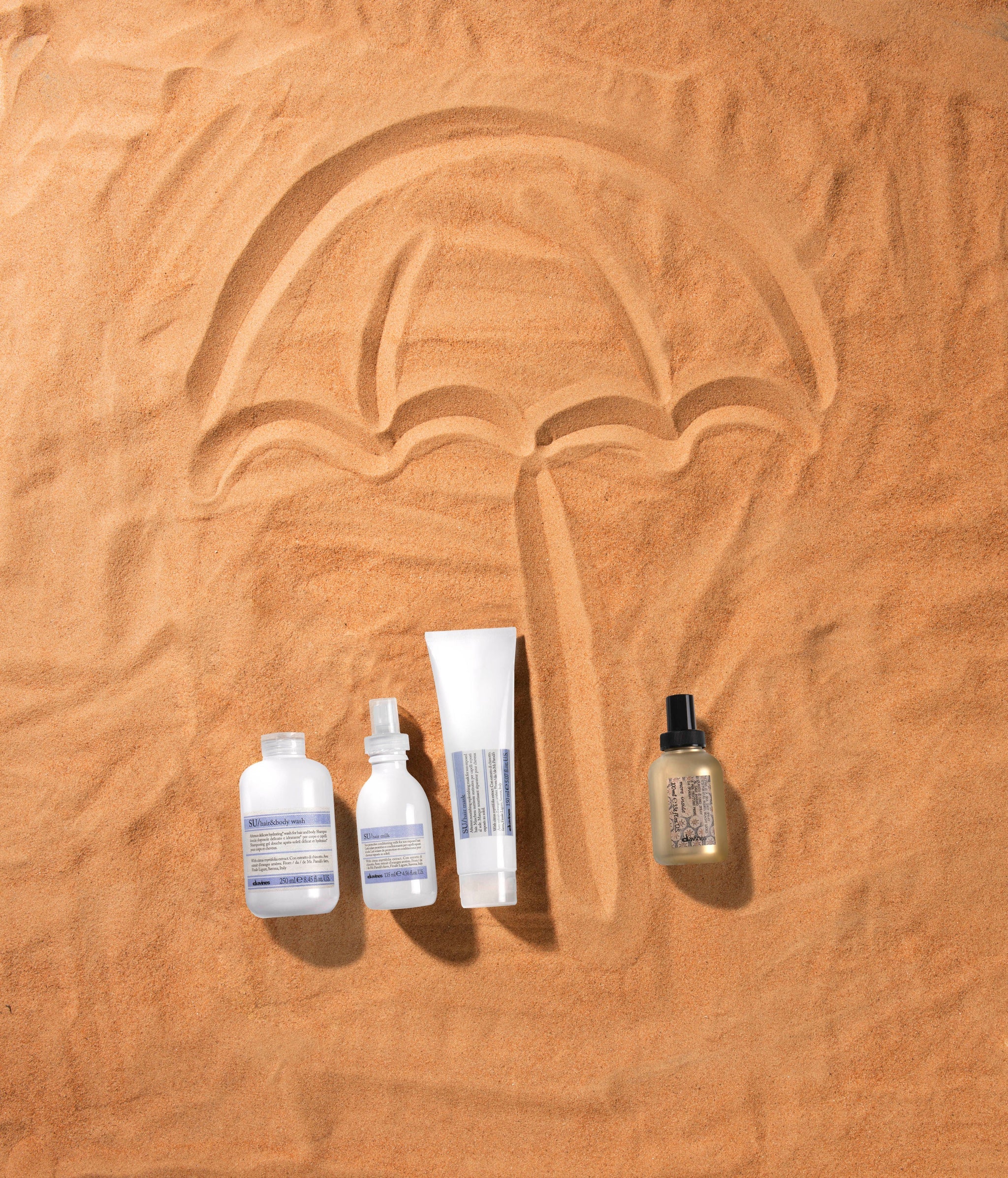 haircare products on a sand background with an umbrella design