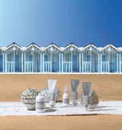 davines products on a wooden surface with beach huts and blue sky in the background