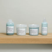 Set of Davines hair care products on a wooden shelf with a neutral background