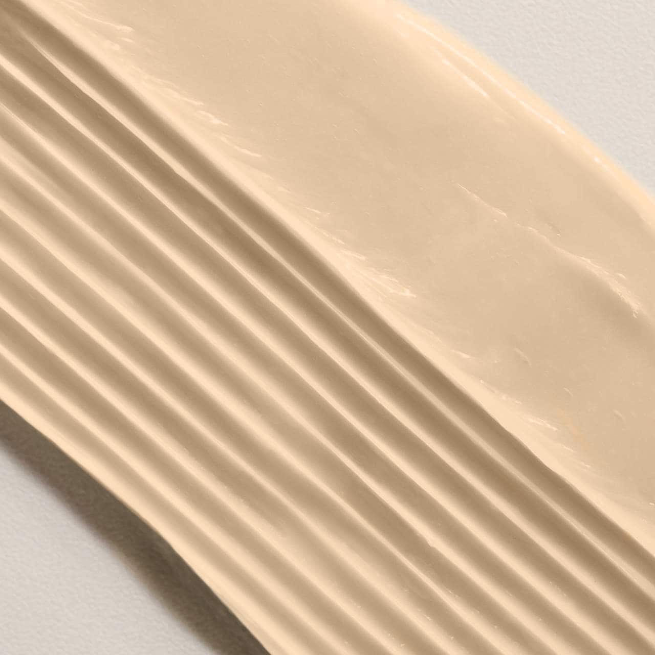 Beige conditioner sample on a light gray background