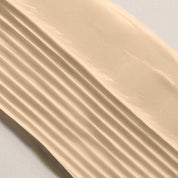 Beige conditioner sample on a light gray background